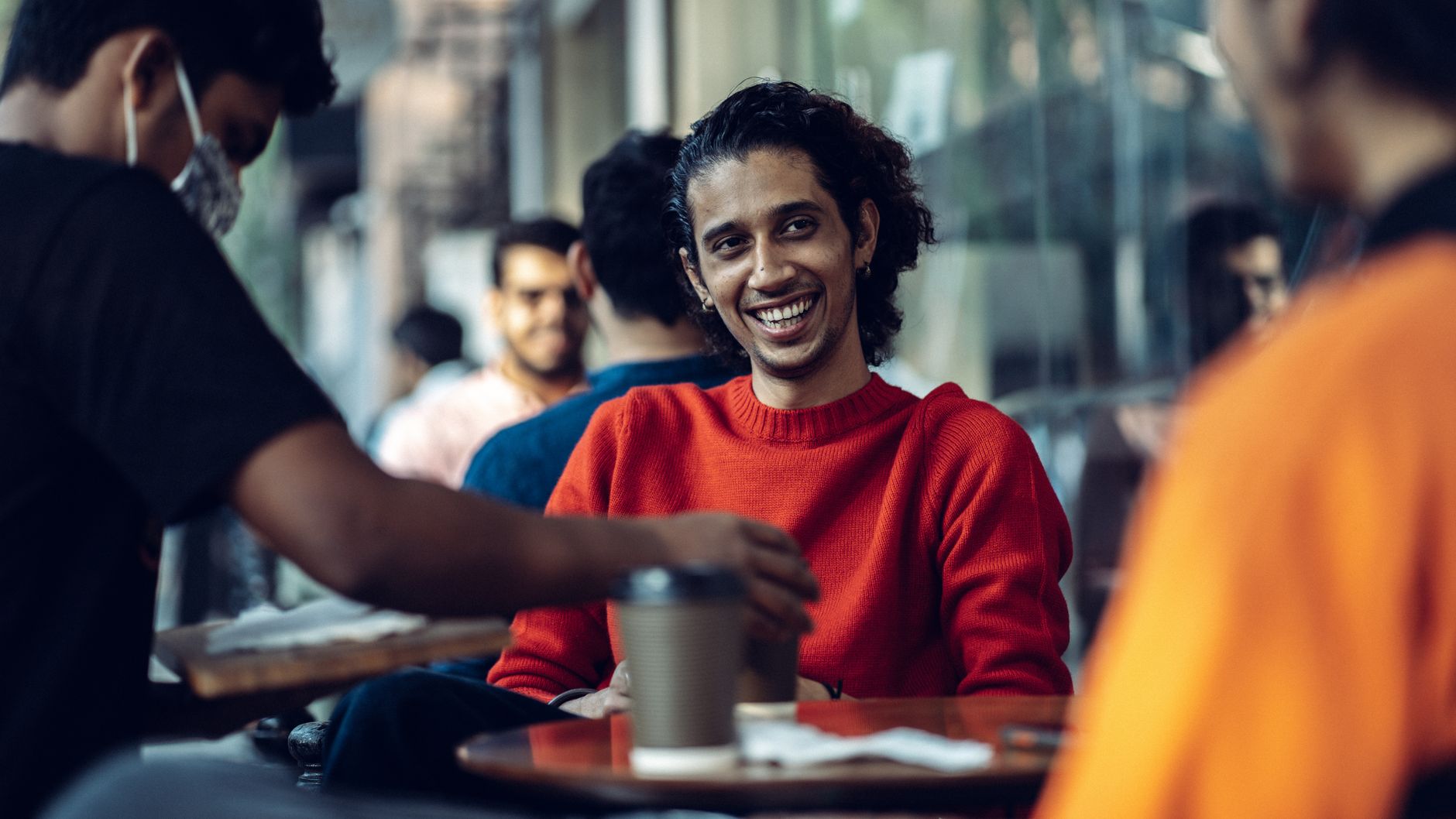 Fröhliche Gäste genießen Kaffee in warmem Café-Ambiente